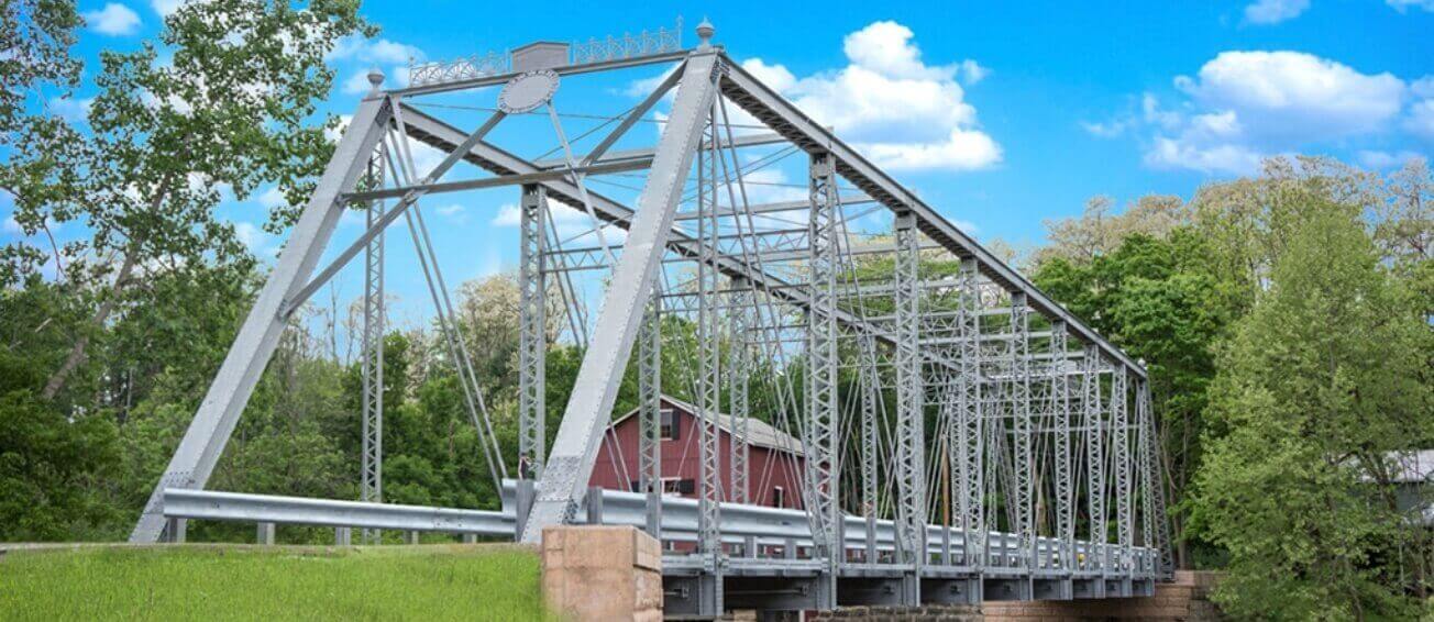 a metal bridge with greenery surrounding it